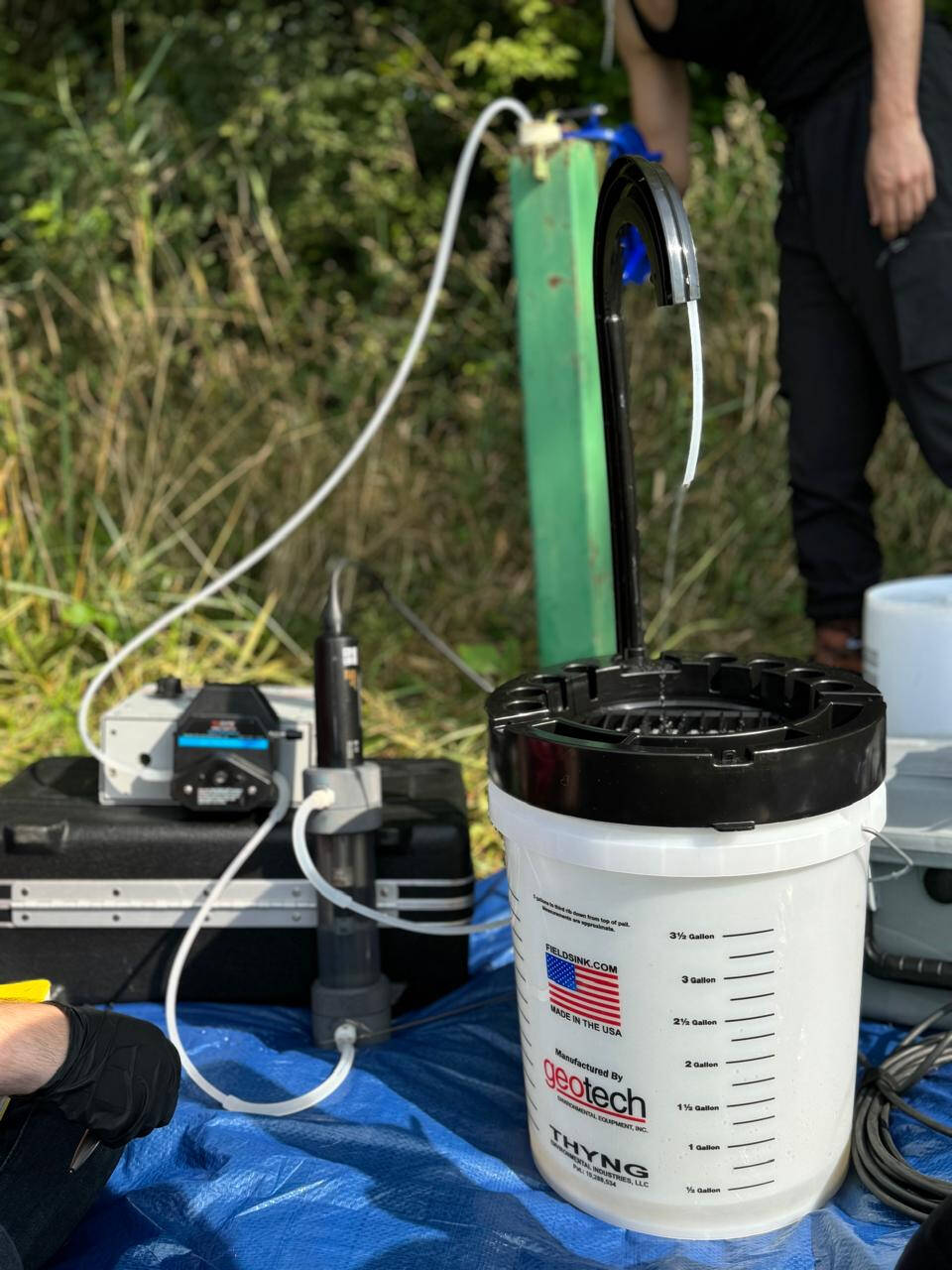 groundwater pump next to a well with a bucket